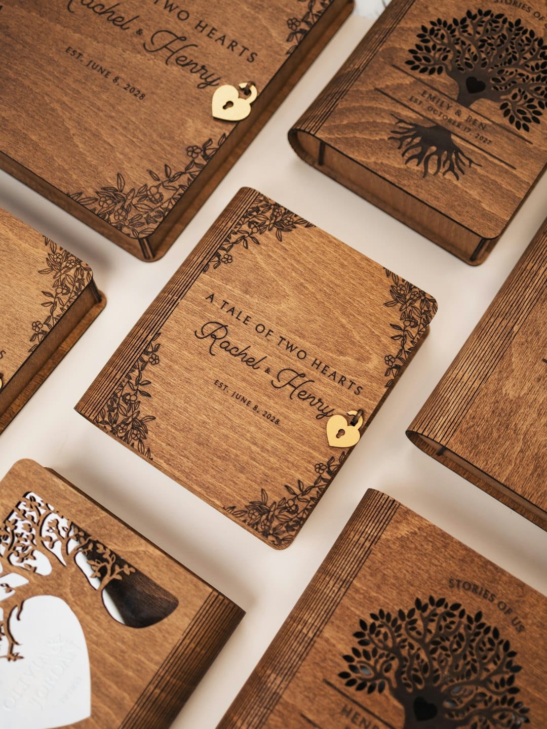 Scatole in legno incise, a forma di libro, con dettagli personalizzati.