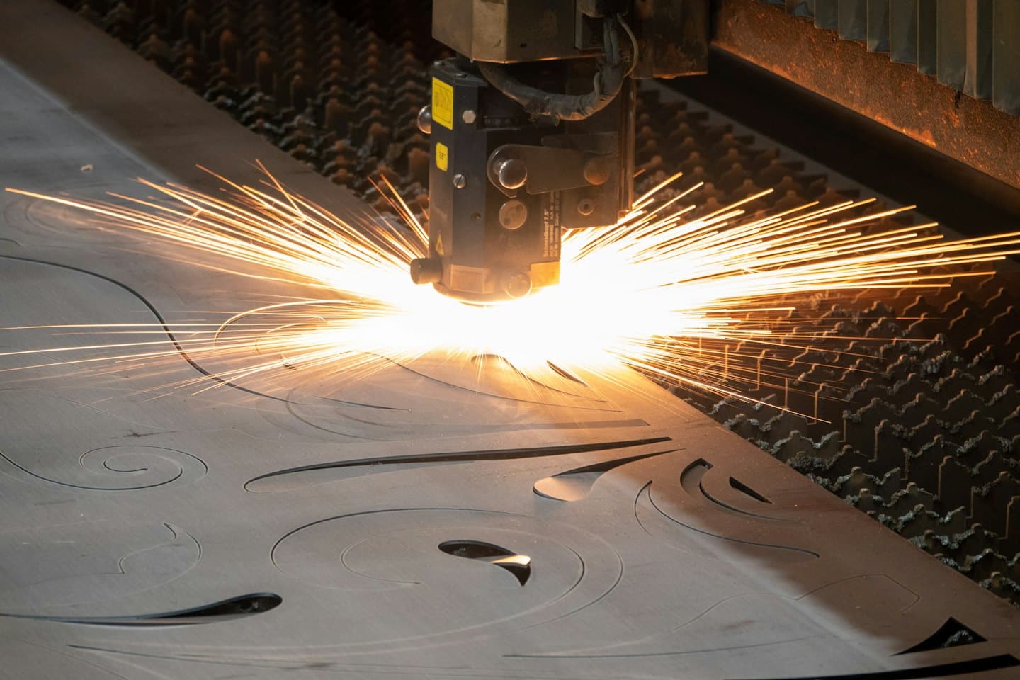 Taglio laser industriale intaglia motivi intricati su lamiera.